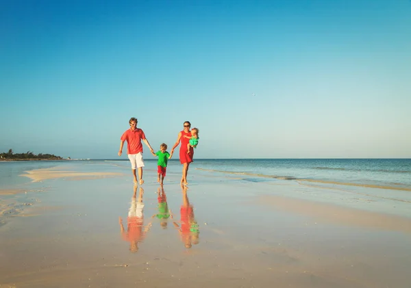 Gelukkig gezin met twee kinderen lopen op strand — Stockfoto