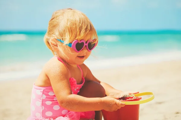 귀여운 작은 소녀가 해변에서 모래를 가지고 노는 모습 — 스톡 사진