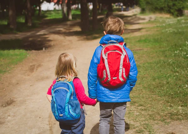 Menino e menina com mochilas indo para a escola — Fotografia de Stock