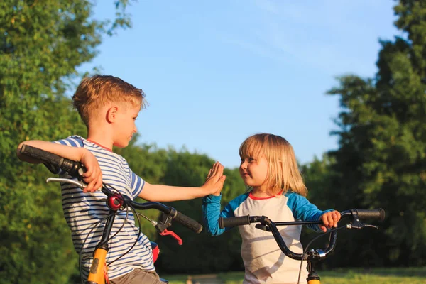 Kleine Jungen und Mädchen auf Fahrrädern in der Natur — Stockfoto