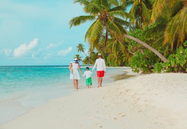 küçük oğlu ve kızı ile mutlu aile sahilde yürümek