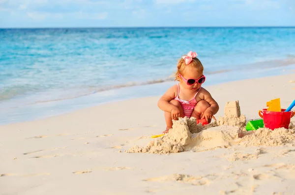 Roztomilý holčička hrát s pískem na pláži — Stock fotografie