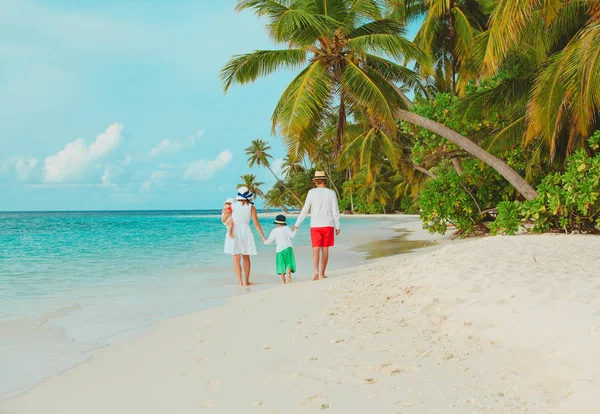 Famille heureuse avec petit fils et fille marcher sur la plage — Photo