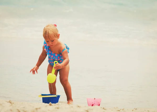 Schattig klein meisje spelen met zand op het strand — Stockfoto