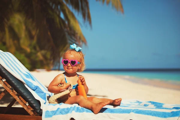 Protezione solare - bambina con crema solare sulla spiaggia — Foto Stock