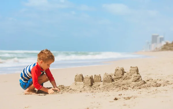 Kleine jongen spelen met zand op strand — Stockfoto