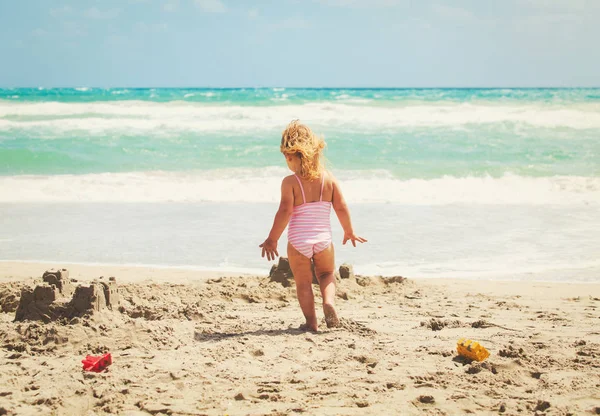 Holčička hrát s pískem na pláži — Stock fotografie