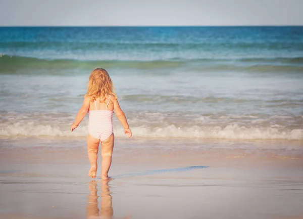 Petite fille va nager sur la plage — Photo