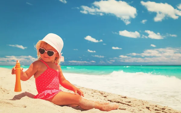 Sun protection - little girl with suncream at beach — Stock Photo, Image