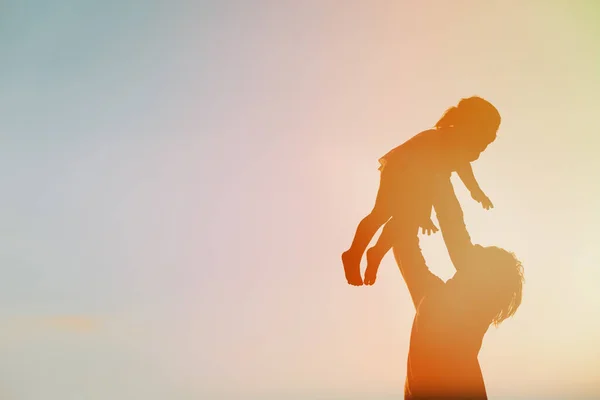 Vater und kleine Tochter spielen am Abendhimmel — Stockfoto