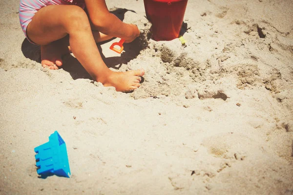 Menina brincar com areia na praia — Fotografia de Stock