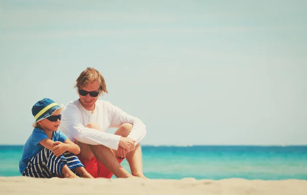 Ο πατέρας και ο μικρός γιος μιλάμε κάθεται στην παραλία — Φωτογραφία Αρχείου