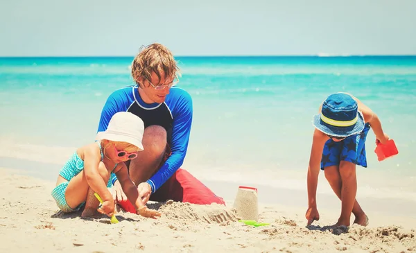 Отец с сыном и дочерью играют на пляже — стоковое фото