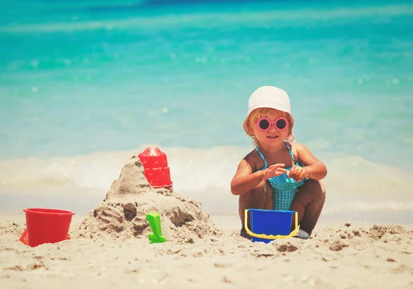 Mignonne petite fille jouer avec le sable sur la plage — Photo