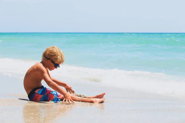 Niño pequeño jugar con arena en la playa — Foto de Stock
