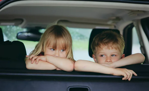 Liten flicka och pojke väntar i bilen — Stockfoto