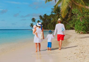 mutlu aile çocuklarla sahilde yürümek