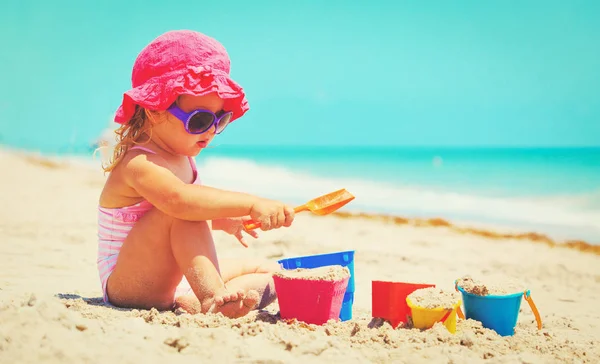 Carino bambina giocare con sabbia sulla spiaggia — Foto Stock