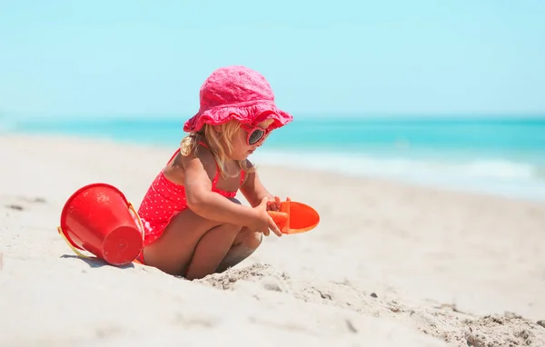 Schattig klein meisje spelen met zand op het strand — Stockfoto