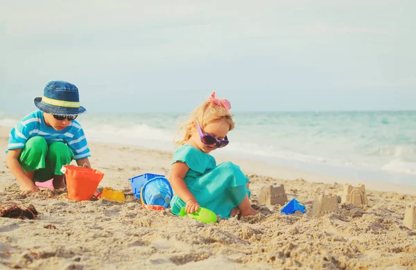 Kisfiú és lány játszani homok a strandon — Stock Fotó