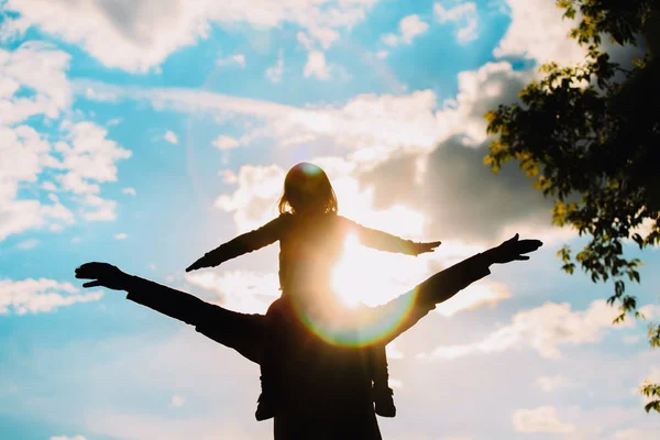 Pai e pequena filha silhuetas jogar ao pôr do sol — Fotografia de Stock