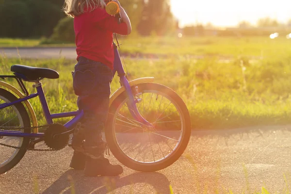 Bambina in sella alla bicicletta al tramonto — Foto Stock