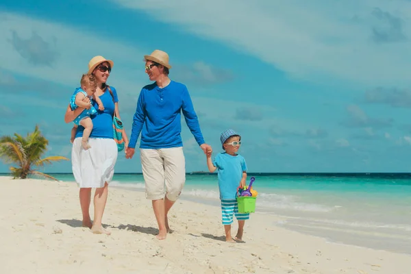 Famille heureuse avec deux enfants marchant sur la plage — Photo