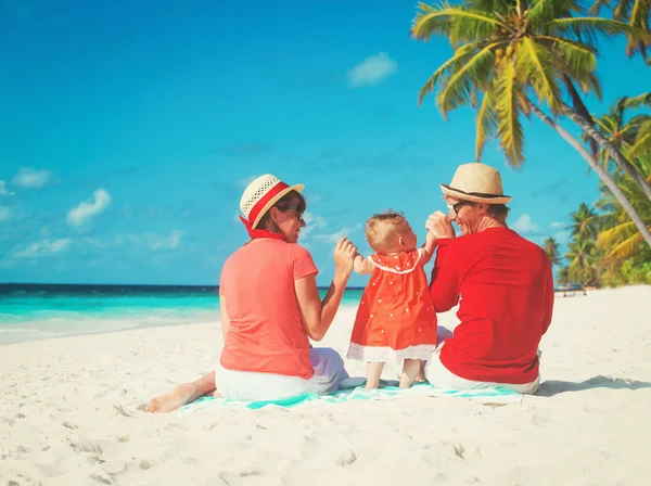 Gelukkig familie met kleine dochter spelen op het strand — Stockfoto