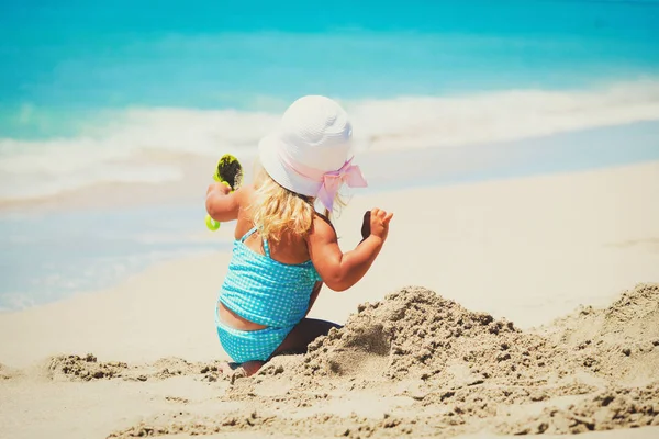 Söt liten flicka leka med sand på stranden — Stockfoto