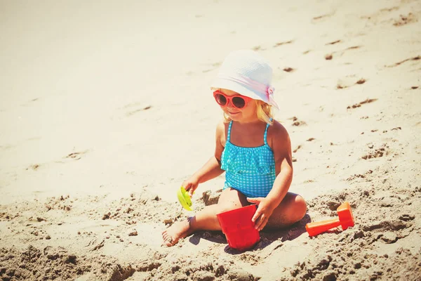 귀여운 작은 소녀가 해변에서 모래를 가지고 노는 모습 — 스톡 사진