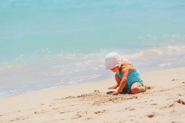 Bonito menina jogar com areia na praia — Fotografia de Stock