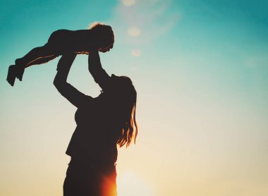 Anne ve küçük kızı günbatımında oynamak