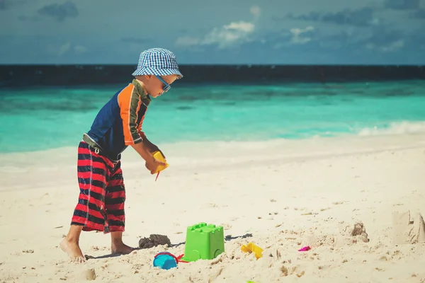 Kleine jongen spelen met zand op strand — Stockfoto