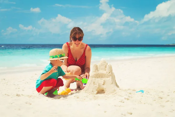 Madre e figlio costruzione castello sulla spiaggia — Foto Stock