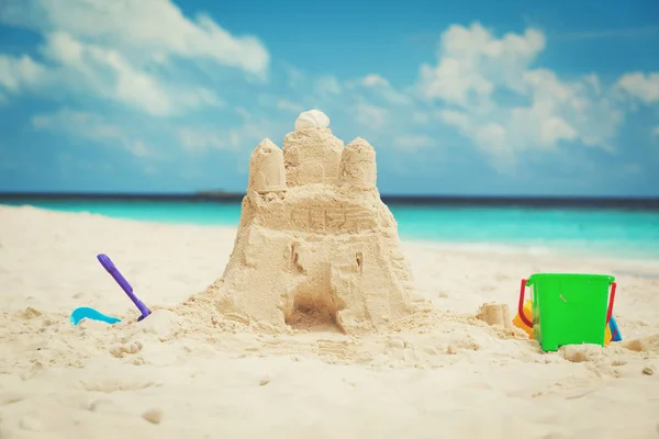 Castello di sabbia sulla spiaggia e giocattoli per bambini — Foto Stock