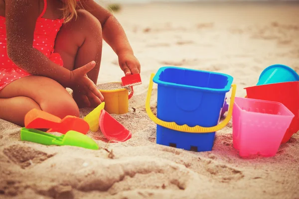Hands of little girl play with sand on beach — Stock Photo, Image
