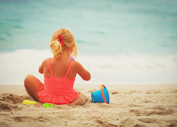 Little girl play with sand on beach — Stock Photo, Image