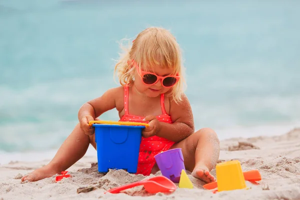 Carino bambina giocare con sabbia sulla spiaggia — Foto Stock