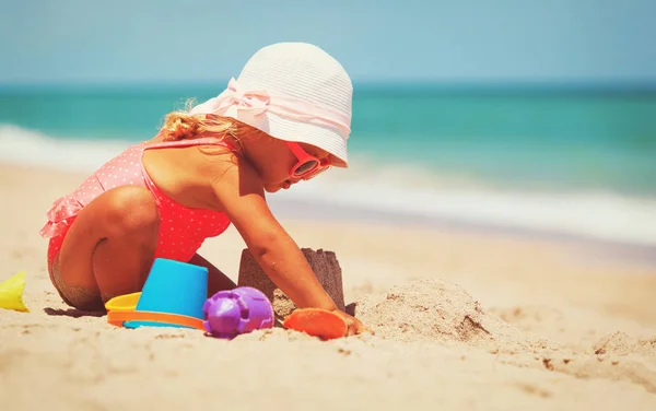 Carino bambina giocare con sabbia sulla spiaggia — Foto Stock