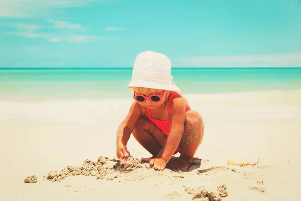 Carino bambina giocare con sabbia sulla spiaggia — Foto Stock