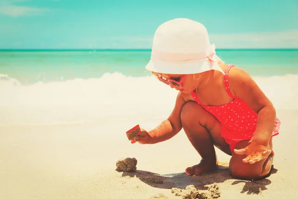 Cute little girl play with sand on beach — Stock Photo, Image