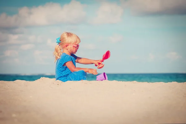 Mignonne petite fille jouer avec le sable sur la plage — Photo