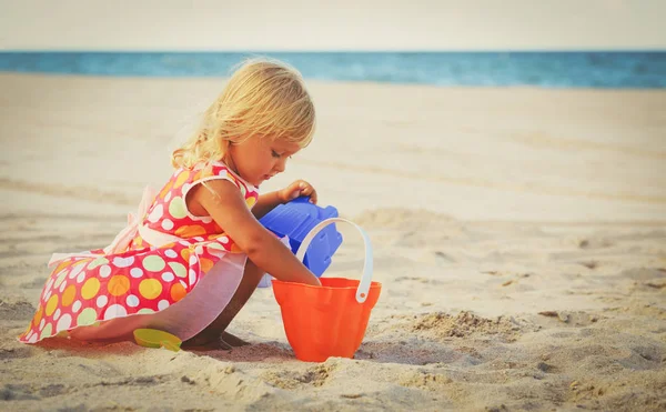 Schattig klein meisje spelen met zand op het strand — Stockfoto