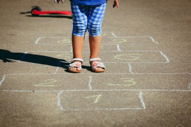 küçük kız oyun parkında seksek oynarken