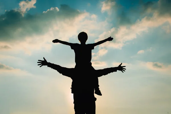 Father and son play on sunset sky — Stock Photo, Image