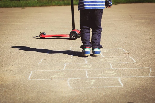 Anak kecil bermain hopscotch di taman bermain — Stok Foto