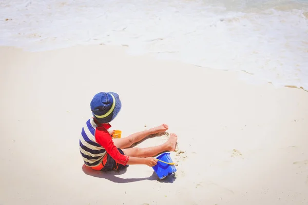 Mały chłopiec grać z piasku na plaży — Zdjęcie stockowe