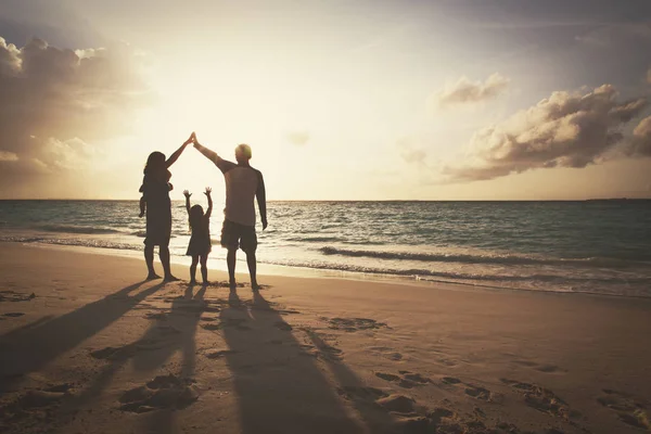 Famille heureuse avec les enfants jouent à la plage du coucher du soleil — Photo