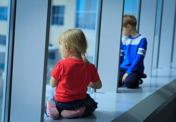 Niño y niña esperando avión en el aeropuerto — Foto de Stock