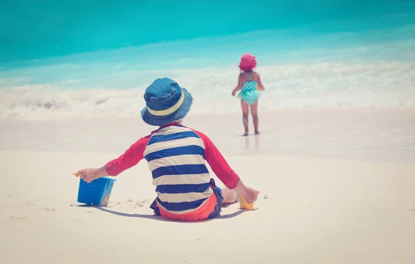 Bambino e ragazza giocare con sabbia sulla spiaggia — Foto Stock